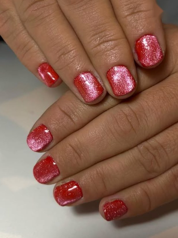 Esmaltado semipermanente rojo con glitter en uñas cortas